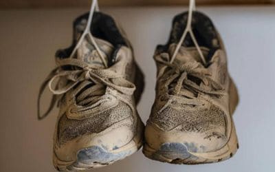 Abgetragene Laufschuhe hängen an einem Haken